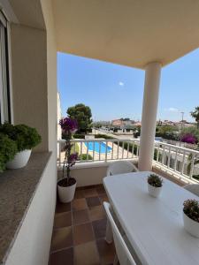 a balcony with a table and a view of a pool at SA CALMA - Duplex con piscina y cerca del Mar - Deltavacaciones in L'Ampolla