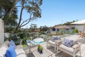 un patio con sillas, una mesa y una piscina en Terrigal Beach House, en Terrigal