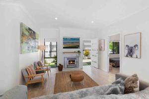 a living room with a couch and a fireplace at Terrigal Beach House in Terrigal