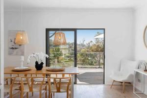 a dining room with a wooden table and chairs at Terrigal Beach House in Terrigal