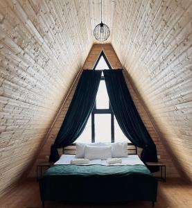 łóżko w pokoju z dużym oknem w obiekcie Memoria Kazbegi w mieście Arsha