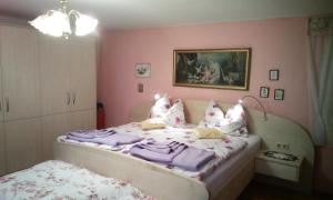 Schlafzimmer mit einem Bett mit lila Bettwäsche und Kissen in der Unterkunft Weinbau-Gästezimmer Martin und Eva Maria Jamek in Weissenkirchen in der Wachau