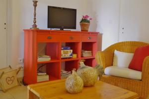 uma sala de estar com uma televisão e uma mesa em La Maison de Lestang em Montbeton