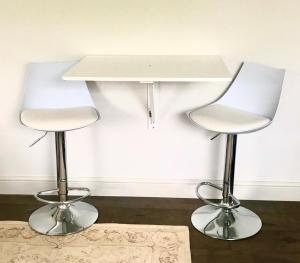 two white chairs sitting next to a table at The Old Post Office Studio Apartment in a Beautiful Cotswold Village in Cirencester