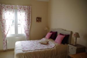 - une chambre avec un lit doté d'oreillers roses et d'une fenêtre dans l'établissement La Maison de Lestang, à Montbeton