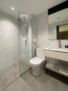 a bathroom with a shower and a toilet and a sink at Hotel Imperial in Kuala Lumpur