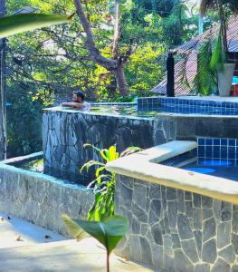 象島的住宿－Jungle Fever Koh Chang，一个人坐在游泳池里