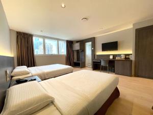 una camera d'albergo con due letti e una televisione di Hotel Imperial a Kuala Lumpur