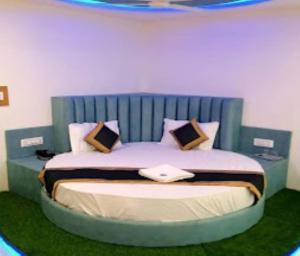 łóżko z niebieskim zagłówkiem w pokoju w obiekcie Hotel Green Leaf,Anand w mieście Anand