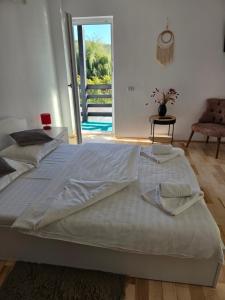 a large white bed in a room with a sliding glass door at Casa Gabrielle in Călimăneşti +36 photos