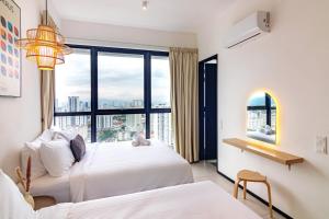 a bedroom with two beds and a large window at Urban Suites, Classic Collection by Stellar ALV in Jelutong