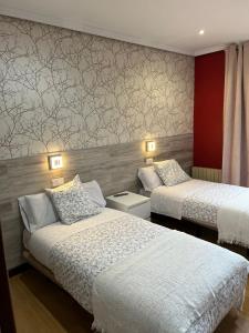 a bedroom with two beds and a wall at Hostal New Dream Madrid in Madrid