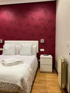 sypialnia z łóżkiem i czerwoną ścianą w obiekcie Hostal New Dream Madrid w Madrycie