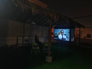 - une télévision dans une tente avec un homme sur un écran dans l'établissement Ashray - Vintage Homes, à Hyderabad