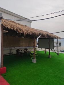 a large straw hut with a screen on the grass at Ashray - Vintage Homes in Hyderabad