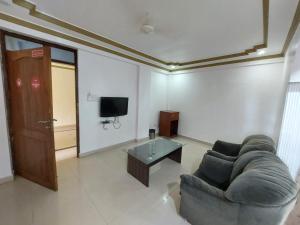 a living room with a couch and a tv at Royal Reosrt Rajbag in Canacona