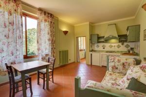 a kitchen and living room with a table and a couch at Albergo Villa San Michele in Greve in Chianti