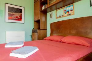 a bedroom with a red bed with two towels on it at La Casa dell’Artista - Appartamento in Milan