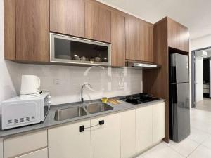 a kitchen with a sink and a microwave at The Podium 3 bedrooms @ 8 pax Free Internet & TV Box in Kuching