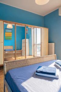 Dormitorio azul con cama con espejo en La Casa dell’Artista - Appartamento, en Milán