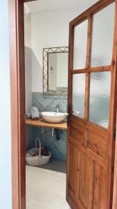 baño con puerta de madera y lavamanos en El Paseo, en Belmonte