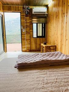 um quarto com uma cama grande e uma janela grande em Nung Gia Homestay em Xin Man