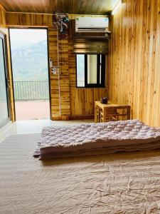 Un dormitorio con una cama grande y una ventana grande. en Nung Gia Homestay, en Xin Man