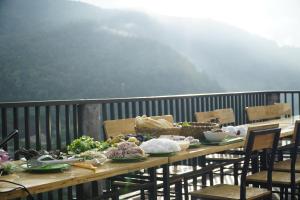 uma mesa com comida em cima de uma varanda em Nung Gia Homestay em Xin Man