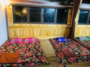 duas camas na parte de trás de um quarto em Nung Gia Homestay em Xin Man