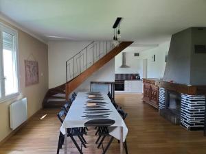un comedor con una mesa larga y una escalera en Maison du Domaine (Gîte), en Chalonnes-sur-Loire