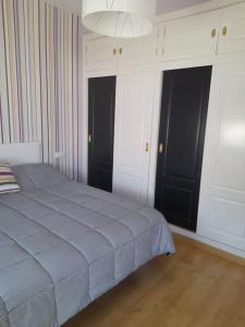 una camera con un letto e due porte nere di Casa acogedora El Carpio, Córdoba a El Carpio