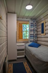 a small bedroom with a bed and a window at Rukajärven Lomamajat Cottage 3 in Kuusamo