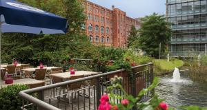 a restaurant with tables and a fountain in a city at Victor's Residenz-Hotel Berlin Tegel in Berlin