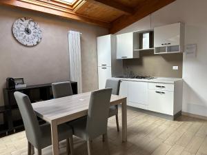 a kitchen and dining room with a wooden table and chairs at B&B Le Mansarde in Pescara