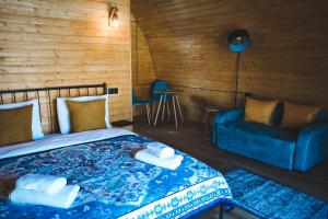 a bedroom with a bed and a blue couch at Kuro Glamping in Stepantsminda