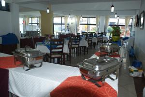 restauracja ze stołami i krzesłami oraz 2 maszynami do jedzenia w obiekcie Westwind Hotel Limited w mieście Meru