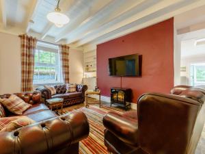a living room with leather furniture and a flat screen tv at 2 bed property in Llandysul 88775 in Llanfihangel-ar-Arth
