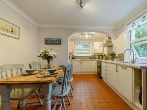 a kitchen and dining room with a wooden table and chairs at 2 bed property in Llandysul 88775 in Llanfihangel-ar-Arth