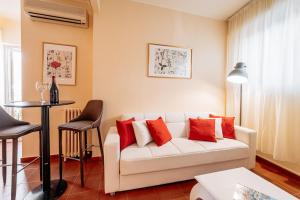 a living room with a white couch and red pillows at A Casitta Luxury Apartments in Taormina