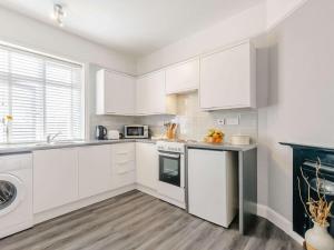 uma cozinha branca com armários brancos e uma máquina de lavar louça em 1 Bed in Broadstairs 89359 em Broadstairs