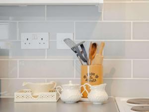 a kitchen counter with a container of utensils at 1 Bed in Broadstairs 89359 in Broadstairs