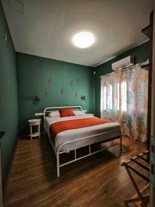 sypialnia z łóżkiem i zieloną ścianą w obiekcie Caravin Wanderhome w Atenach