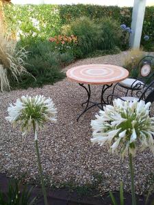un tavolo e due fiori bianchi in un giardino di Girasole Boutique B&B a Riola Sardo