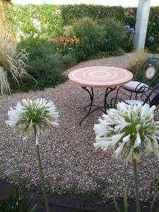 a table and two white flowers in a garden at Girasole Boutique B&B in Riola Sardo