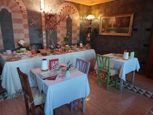 uma sala de jantar com duas mesas com toalhas de mesa brancas em B&b Ca'Baracca Bellavista em Bassano del Grappa