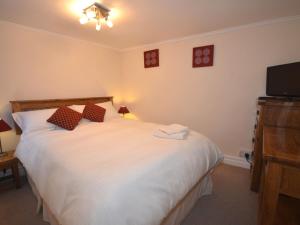 sypialnia z dużym białym łóżkiem i telewizorem z płaskim ekranem w obiekcie 2 Bed in Clovelly FORDM w mieście Woolfardisworthy