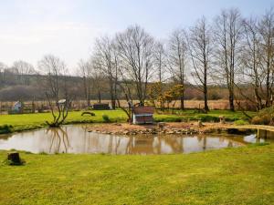 a park with a pond and a bench in the grass at 2 Bed in Clovelly FORDM in Woolfardisworthy