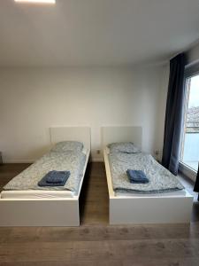 two twin beds in a room with a window at Stay-Happy Flat in Halstenbek in Halstenbek