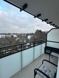 einen Balkon mit einer Bank und schneebedeckten Bäumen in der Unterkunft Stay-Happy Flat in Halstenbek in Halstenbek