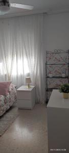 a bedroom with a bed and a table with a lamp at Apartamento frente a Palacio de Congresos (Fibes) in Seville